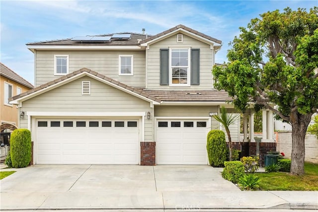 traditional home featuring brick siding, roof mounted solar panels, an attached garage, and a tile roof