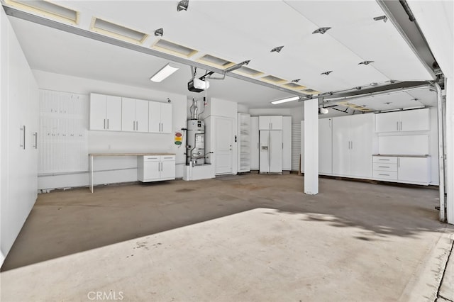 garage featuring secured water heater, white refrigerator with ice dispenser, and a garage door opener