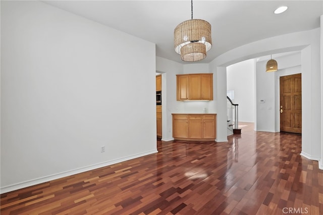 interior space with dark wood-type flooring and a chandelier