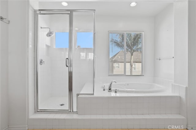 full bath featuring a shower stall and a garden tub