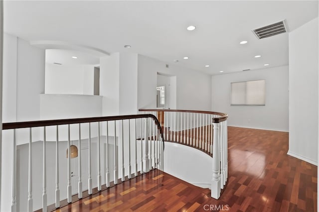 hallway with visible vents, an upstairs landing, wood finished floors, recessed lighting, and baseboards