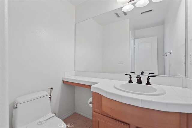 bathroom featuring vanity, tile patterned floors, and toilet