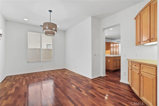 unfurnished dining area with dark wood-type flooring