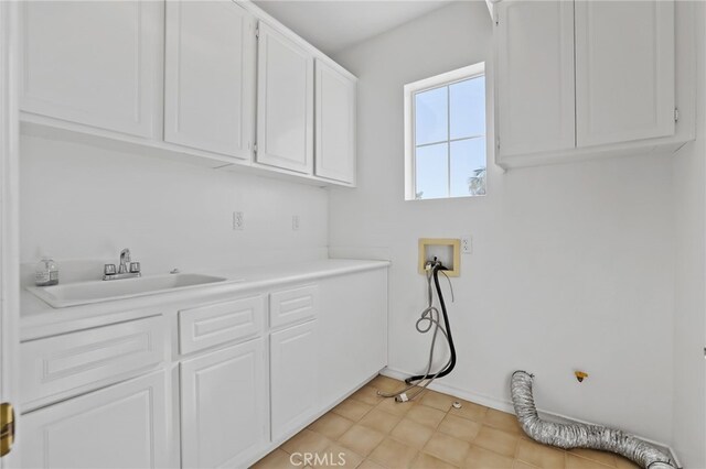 clothes washing area featuring washer hookup, sink, and cabinets