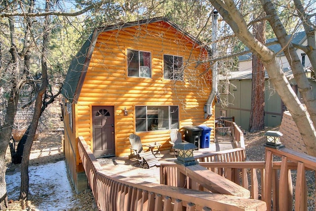 rear view of house featuring a wooden deck