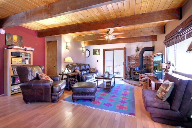 living room with wood ceiling, light hardwood / wood-style flooring, ceiling fan, beam ceiling, and a wood stove