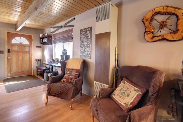 living area featuring light hardwood / wood-style flooring, wooden ceiling, and beamed ceiling