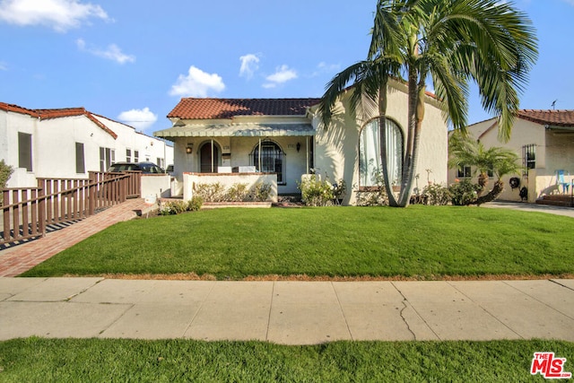 mediterranean / spanish house featuring a front yard