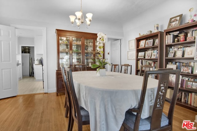 dining area featuring an inviting chandelier and light wood-type flooring