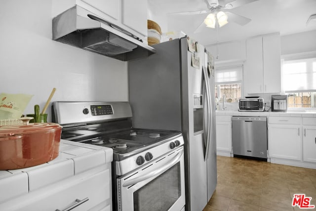 kitchen with white cabinetry, appliances with stainless steel finishes, tile counters, dark tile patterned flooring, and ceiling fan