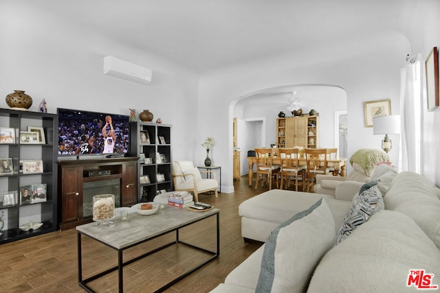 living room featuring dark hardwood / wood-style flooring and a wall unit AC