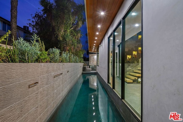 view of pool at twilight