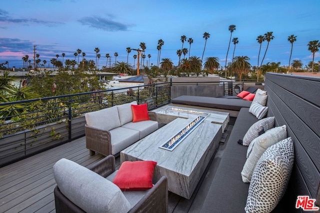 deck at dusk featuring an outdoor hangout area