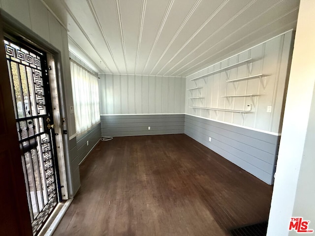 empty room with wooden walls and dark hardwood / wood-style flooring