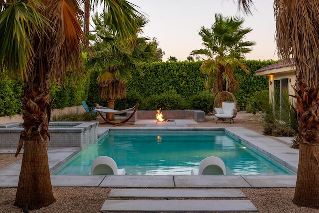 view of swimming pool with an outdoor fire pit and a patio