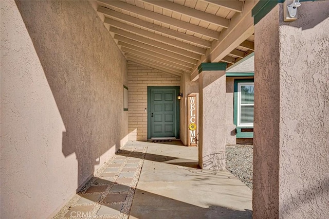 view of exterior entry with a patio