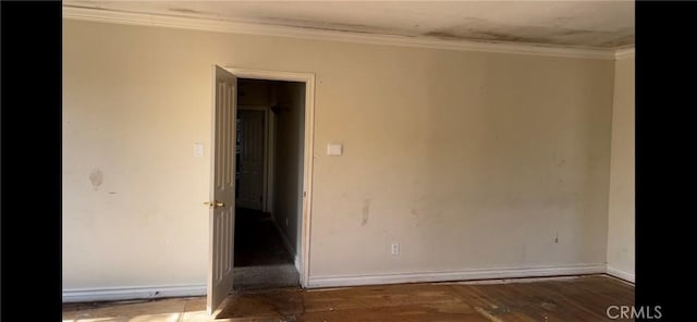 spare room featuring ornamental molding and dark wood-type flooring