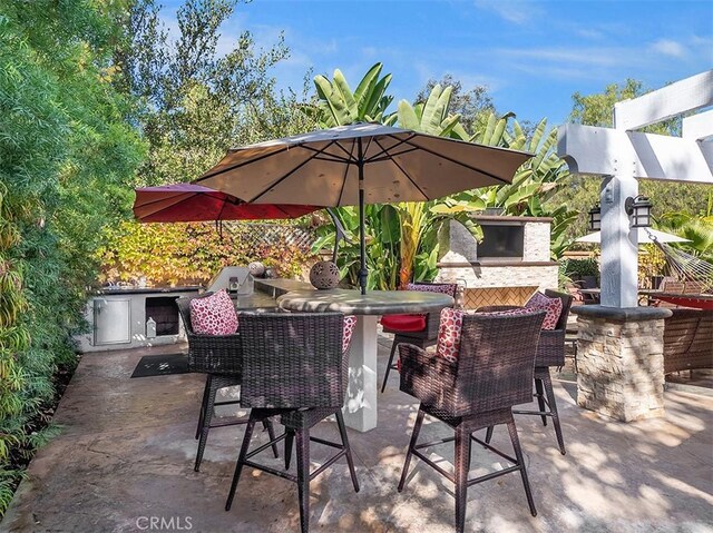 view of patio / terrace with a bar and an outdoor kitchen