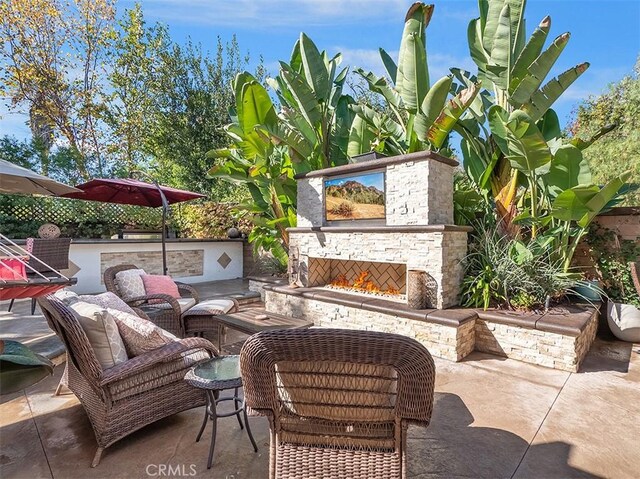 view of patio with an outdoor living space with a fireplace