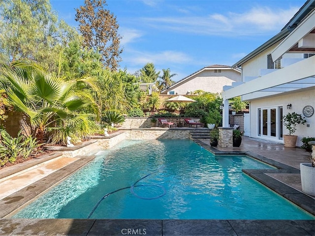 view of pool featuring a patio area and french doors