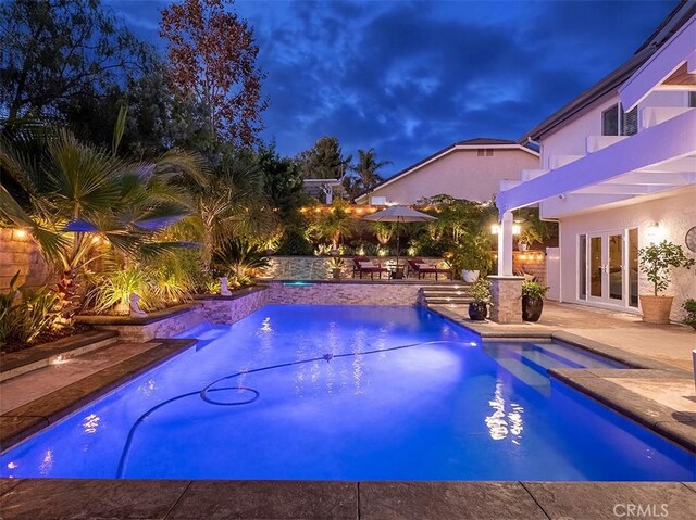 view of pool featuring a patio area, a hot tub, and french doors