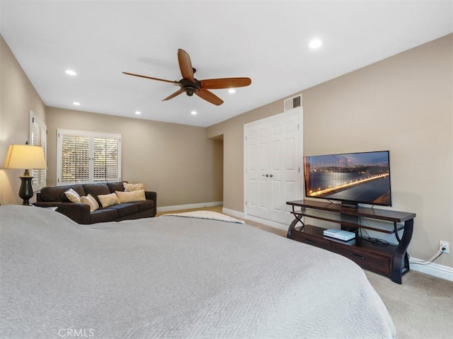 carpeted bedroom with ceiling fan and a closet