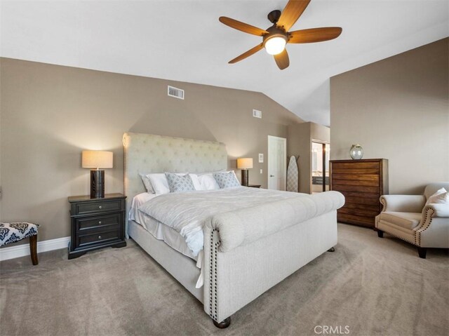 carpeted bedroom with ceiling fan, lofted ceiling, and ensuite bathroom