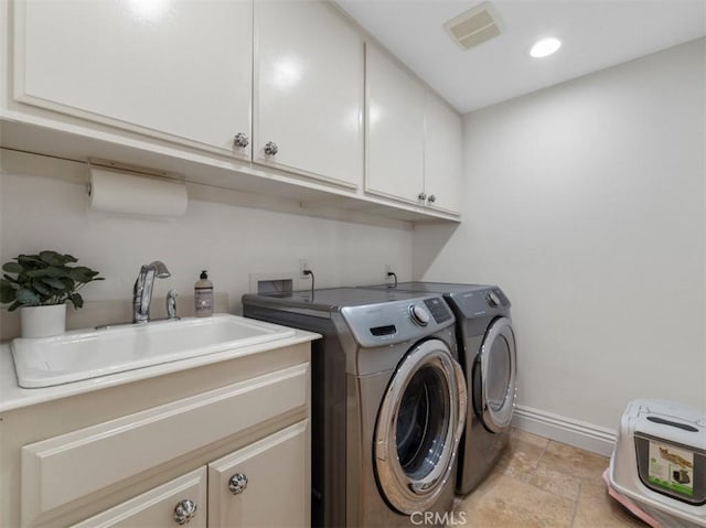 laundry room featuring cabinets, sink, and washer and dryer