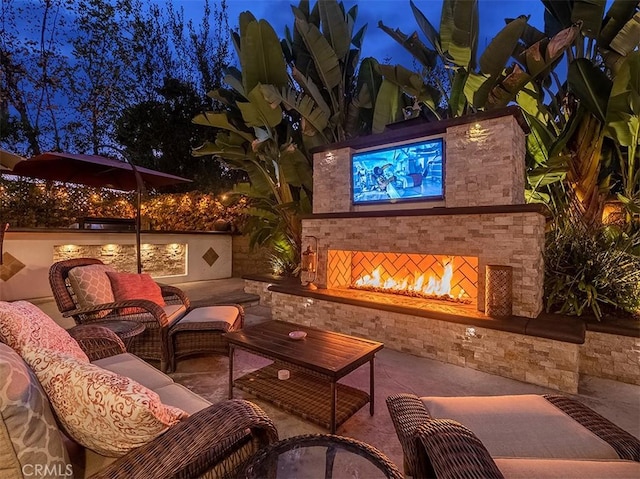 view of patio with an outdoor living space with a fireplace