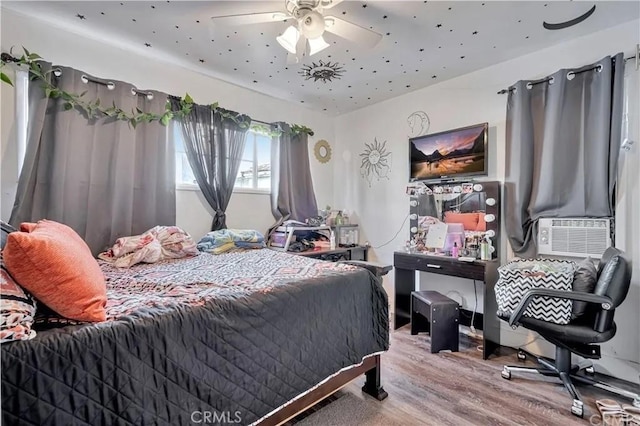 bedroom with wood-type flooring, cooling unit, and ceiling fan