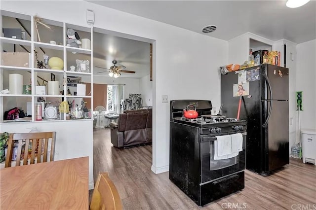 kitchen featuring hardwood / wood-style floors, ceiling fan, and black appliances