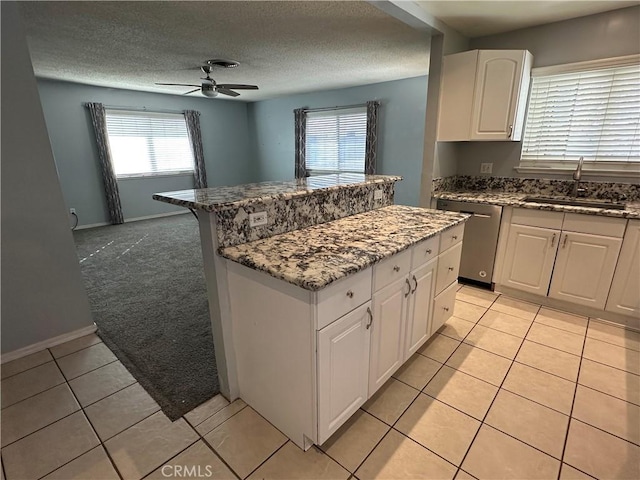 kitchen featuring sink, dishwasher, and white cabinets