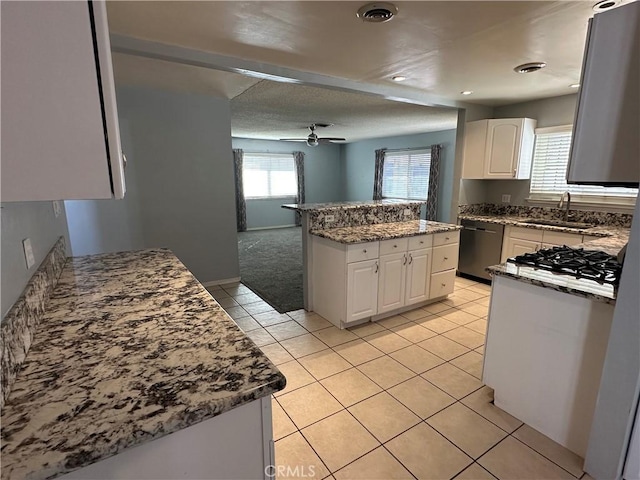 kitchen featuring sink, dishwasher, ceiling fan, white cabinets, and light colored carpet