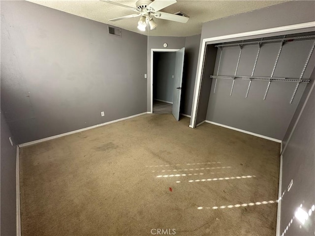 unfurnished bedroom featuring carpet flooring, a textured ceiling, ceiling fan, and a closet