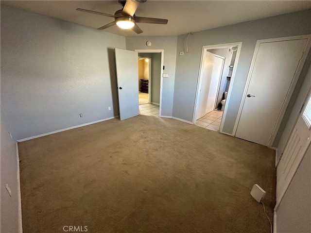 unfurnished bedroom with light carpet, ceiling fan, and ensuite bathroom