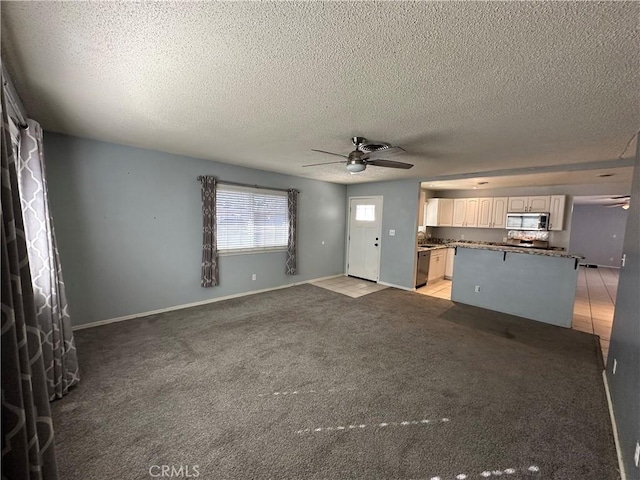 unfurnished living room featuring light carpet, a textured ceiling, and ceiling fan