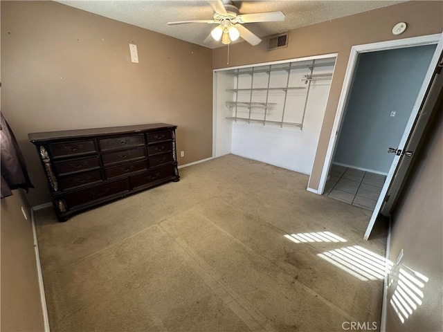 carpeted bedroom featuring a textured ceiling, ceiling fan, and a closet