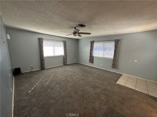 carpeted empty room featuring plenty of natural light, a textured ceiling, and ceiling fan