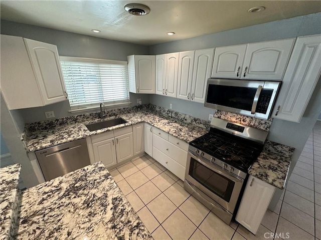 kitchen with appliances with stainless steel finishes, sink, and white cabinets
