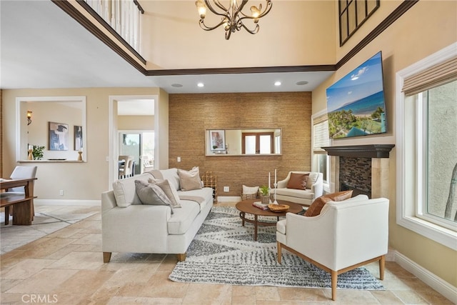 living room featuring a towering ceiling, a notable chandelier, and a fireplace