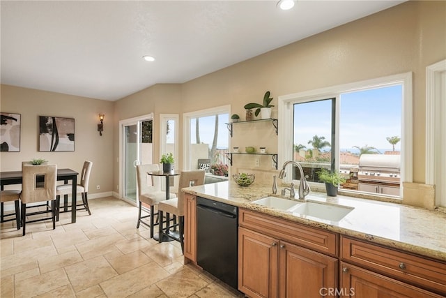 kitchen with sink, a wealth of natural light, light stone countertops, and black dishwasher