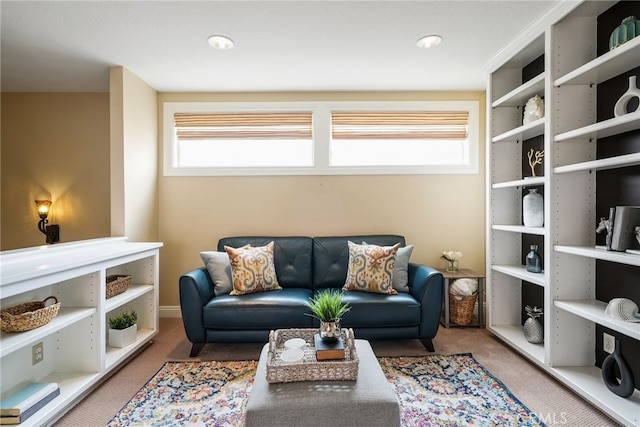 living area featuring plenty of natural light and carpet flooring