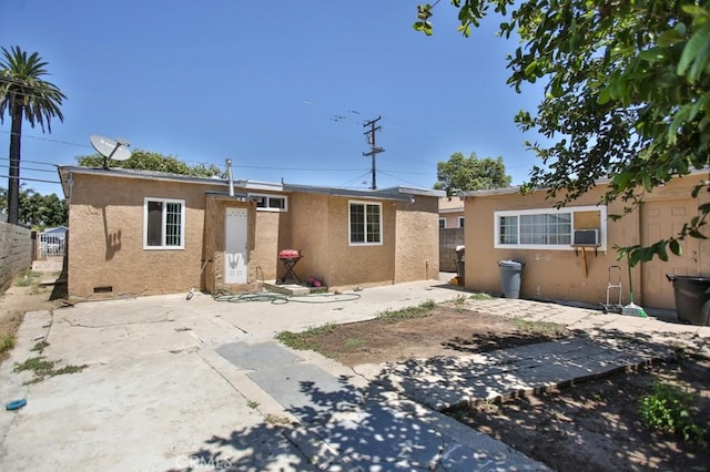 view of front of home with fence, a patio, and stucco siding