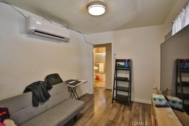 living room featuring an AC wall unit, wood finished floors, and baseboards