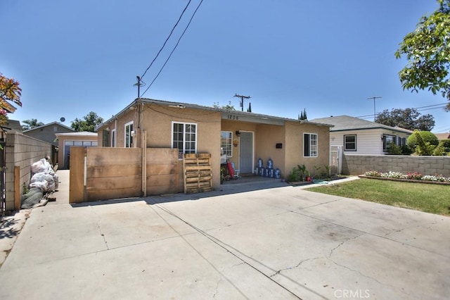 view of front of property with a gate, fence, and stucco siding