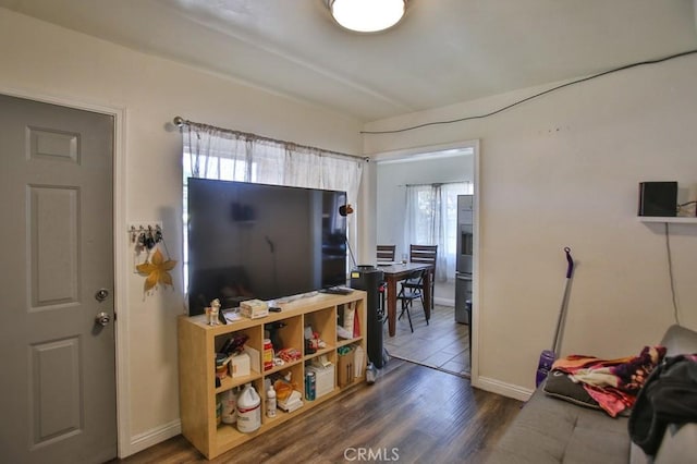 living area with baseboards and wood finished floors