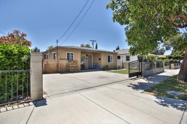 single story home featuring a fenced front yard, a gate, and stucco siding