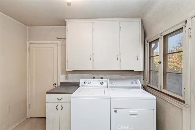 laundry area with washing machine and dryer and cabinets