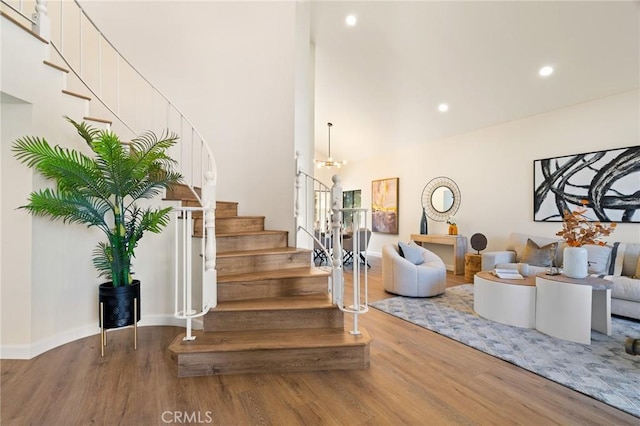 staircase featuring hardwood / wood-style flooring and a notable chandelier