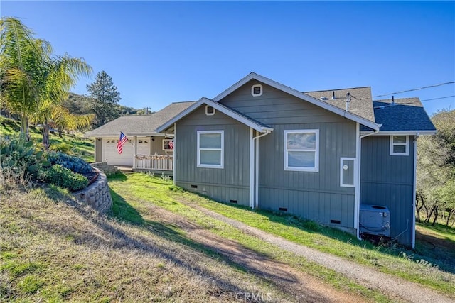 view of home's exterior featuring a garage, a yard, and central AC unit